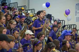 The high school band performs from the gym bleachers during the pep rally