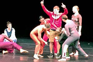 Students interact with dancers on stage.