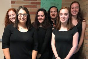 Orchestra students pose together in formal dress
