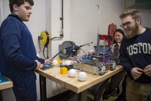 Three students work on A-B, the Robot team's creation