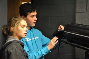 Two students operating stage lights