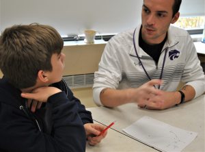 Teacher talking with student and drawing on a sheet of paper