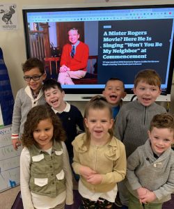 kindergarteners standing in front of a Mr. Rogers photo