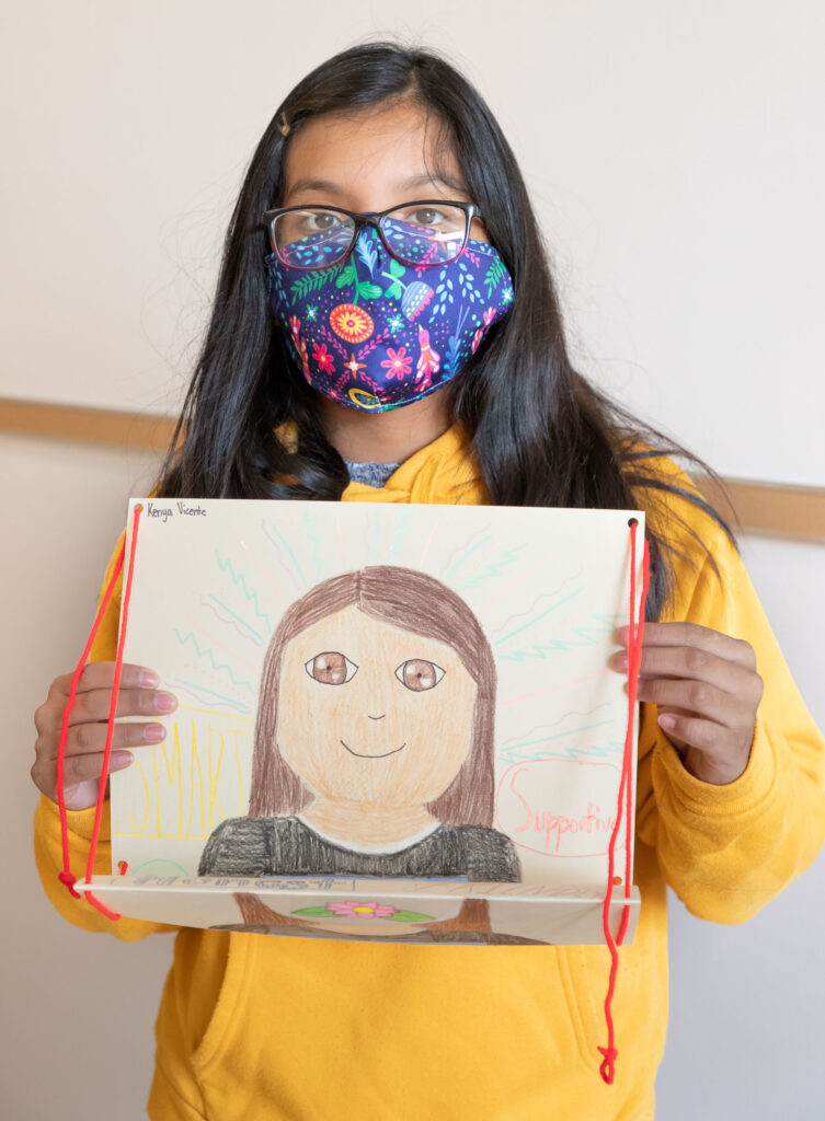 Sixth grader Kenya Vicente holds up a self portrait she did as part of a class project at Warwick Valley Middle School on Sept. 21, 2020.