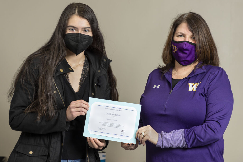 Warwick Valley High School Principal Marguerite Fusco presents senior Simone Sullivan with a Certificate of Merit for being named a finalist in the National Merit Scholarship program on Feb. 12, 2021.