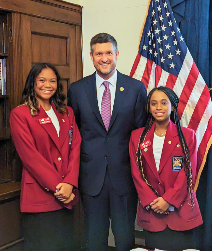 Kayla Flores (right), Angelina Vargas from S.S. Seward Institute (left) with Congressman Pat Ryan (center)