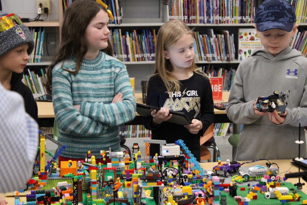 students talking in front of LEGO project