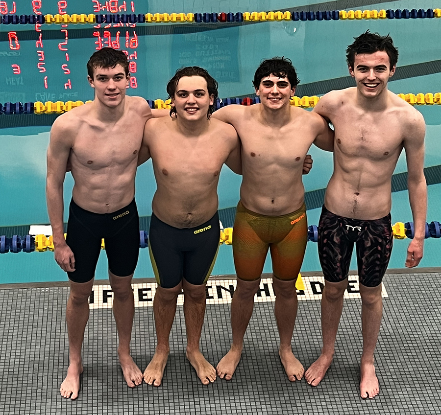 Four Warwick swimmers pose for a photo by the pool
