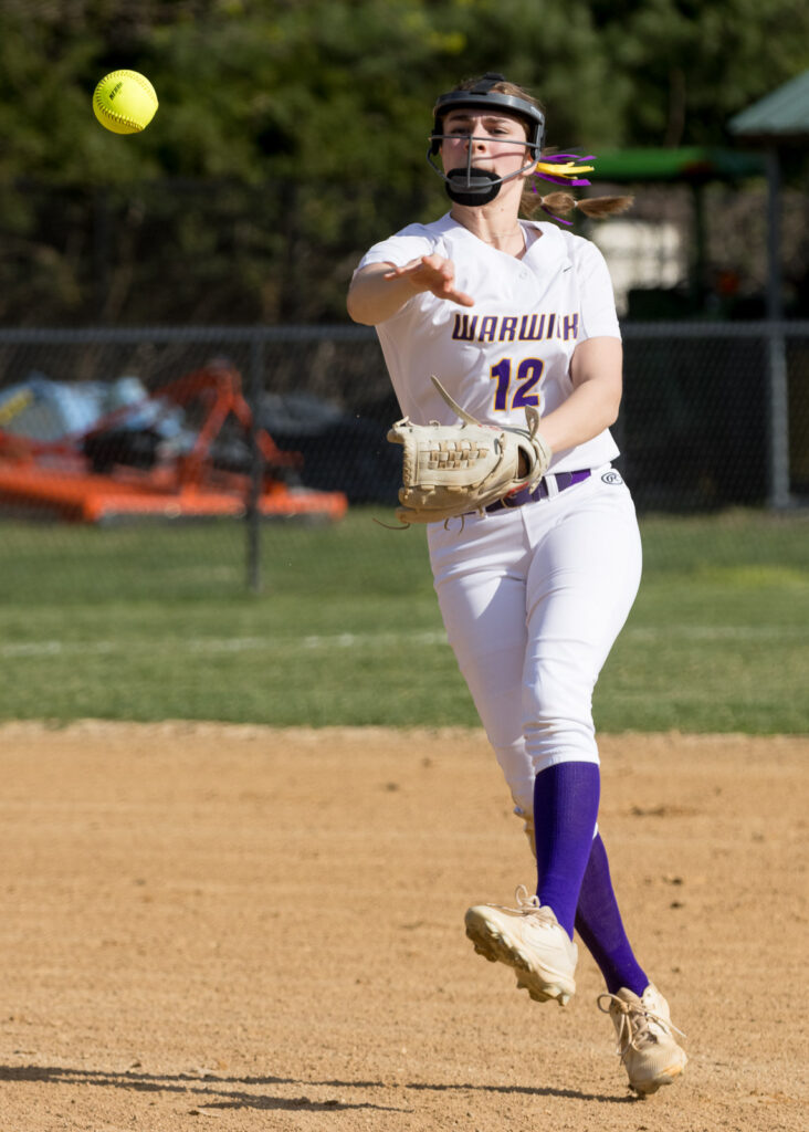 Warwick softball player throws the ball to first base.
