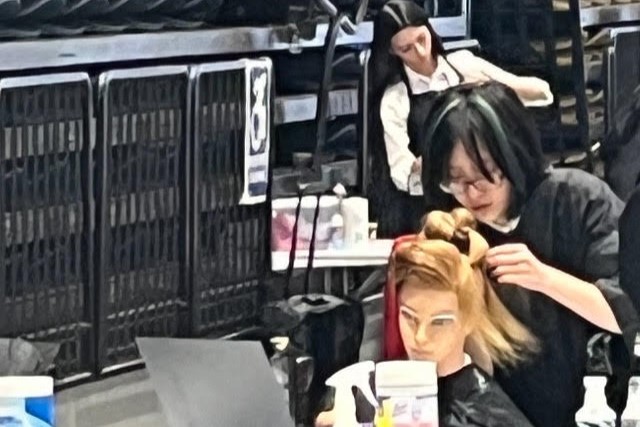 A student works on a mannequin's hair during New York State SkillsUSA competition.