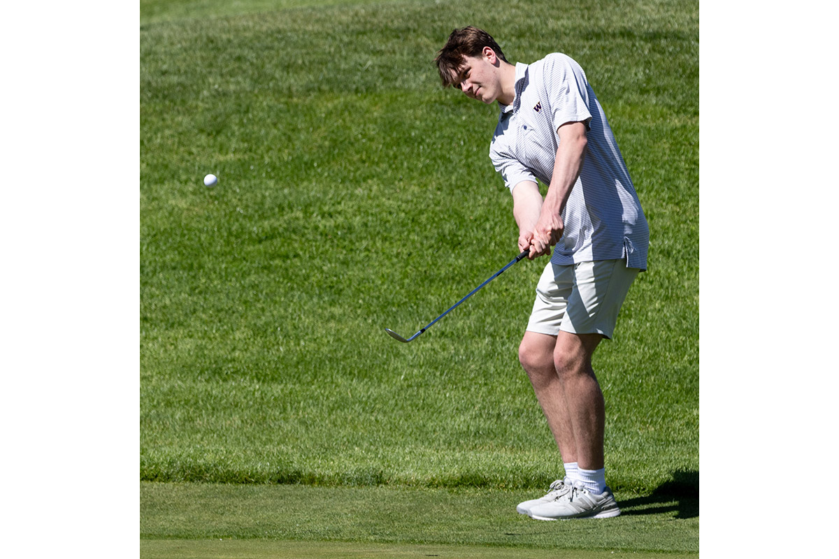 A Warwick Valley High School varsity boys golfer chips the ball.