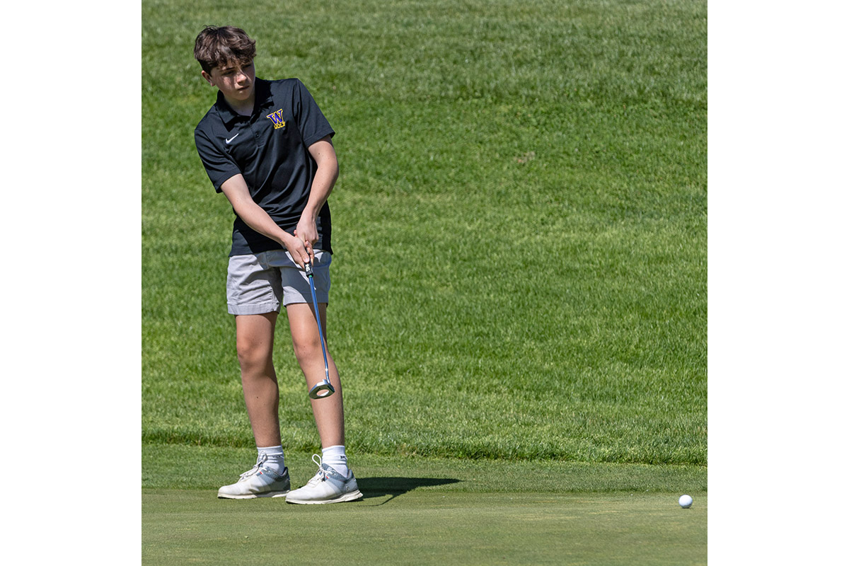 A Warwick Valley High School varsity boys golfer putts the ball.