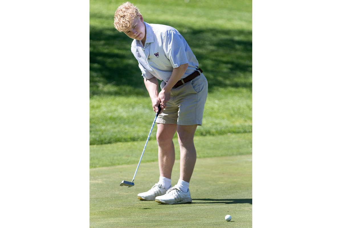 A Warwick Valley High School varsity boys golfer putts the ball.