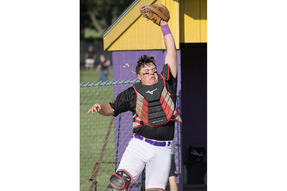 Warwick Valley High School varsity baseball catcher jumps to catch the ball.