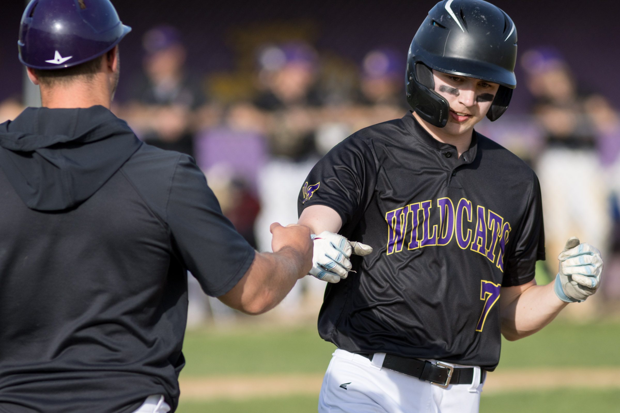 A Warwick Valley High School varsity baseball player first bumps the first base coach.