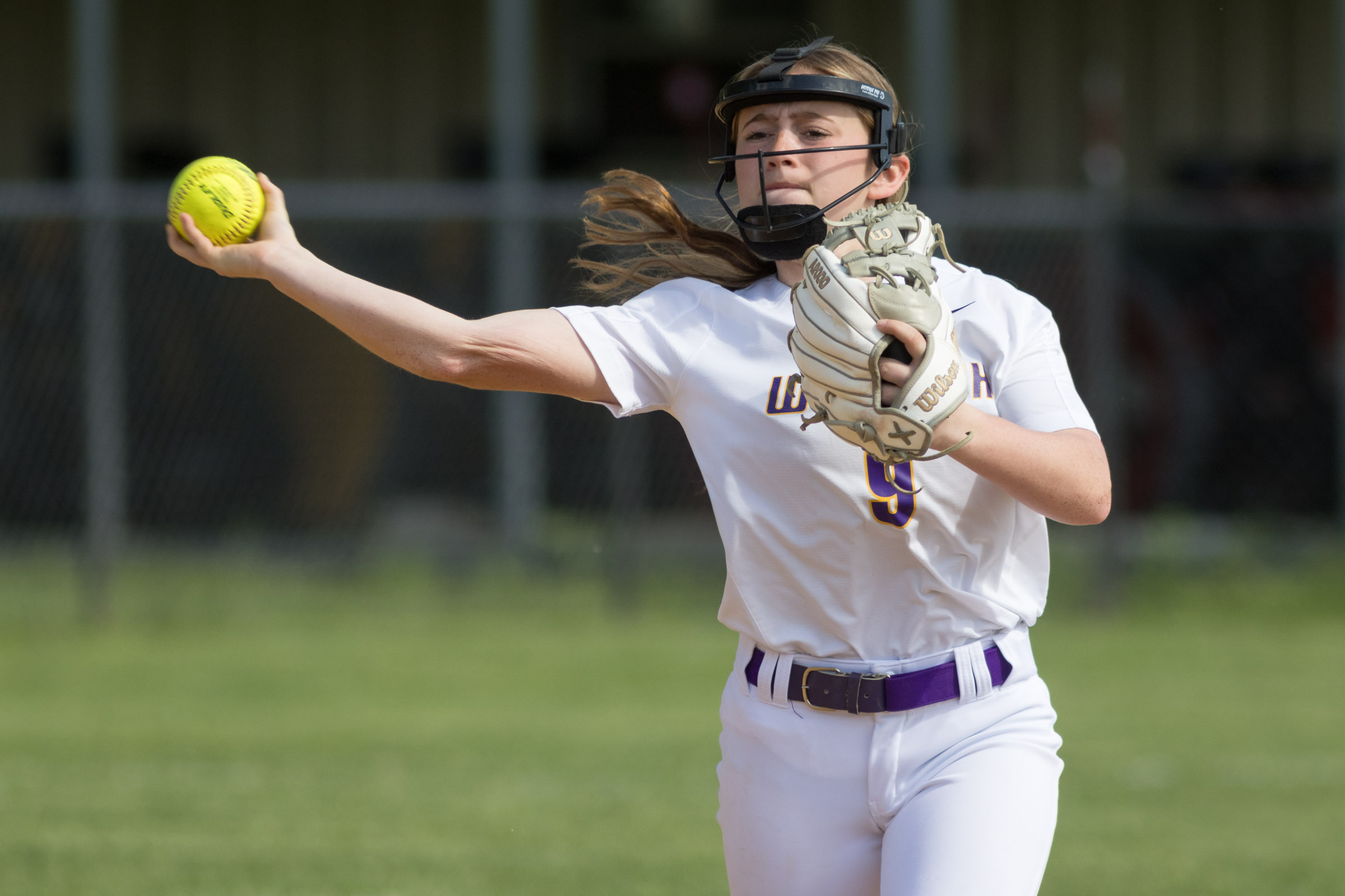 A Warwick Valley High School varsity softball infielder throws the ball to first base.