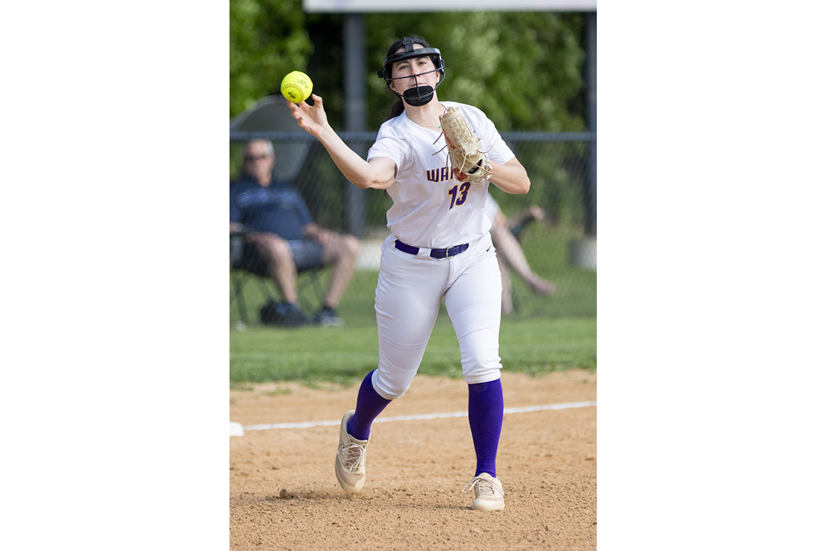 A Warwick Valley High School varsity softball infielder throws the ball to first base.