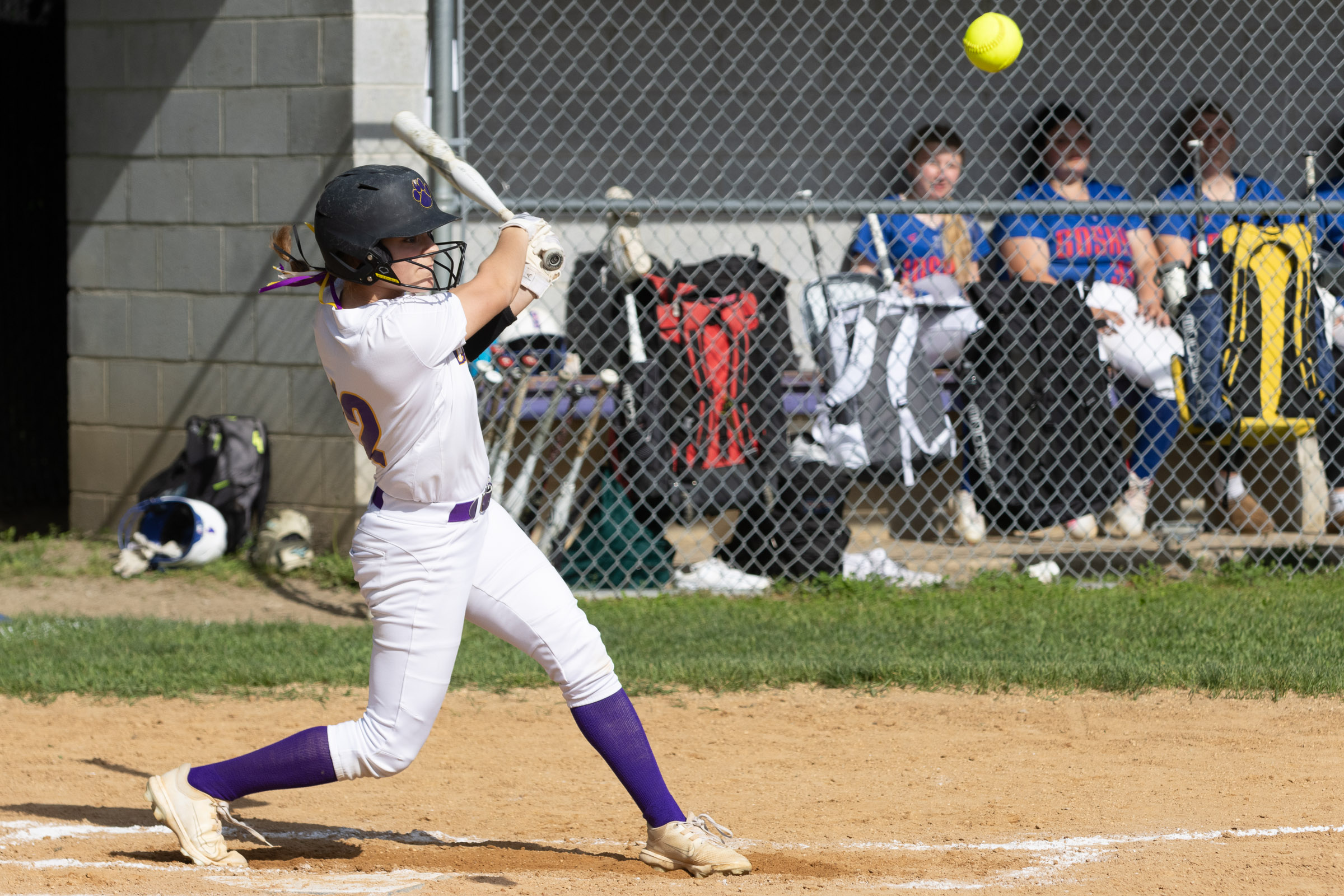 A Warwick Valley High School varsity softball batter follows through on her swing as the ball flies away.