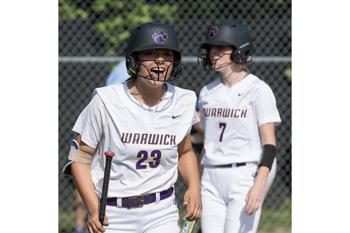 A Warwick Valley High School varsity softball batter smiles in celebration after her team scored.