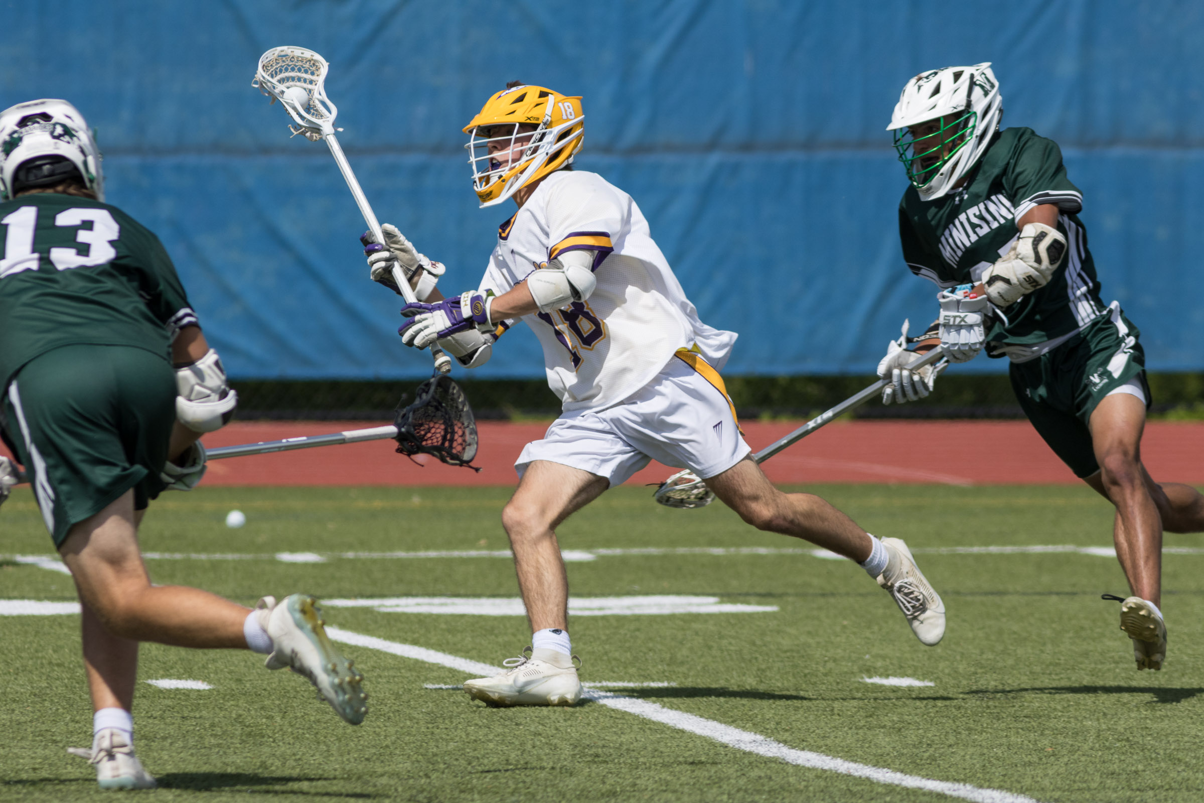 A Warwick Valley varsity boys lacrosse player carries the ball between two Minisink Valley players during the Section 9 Class B championship game.