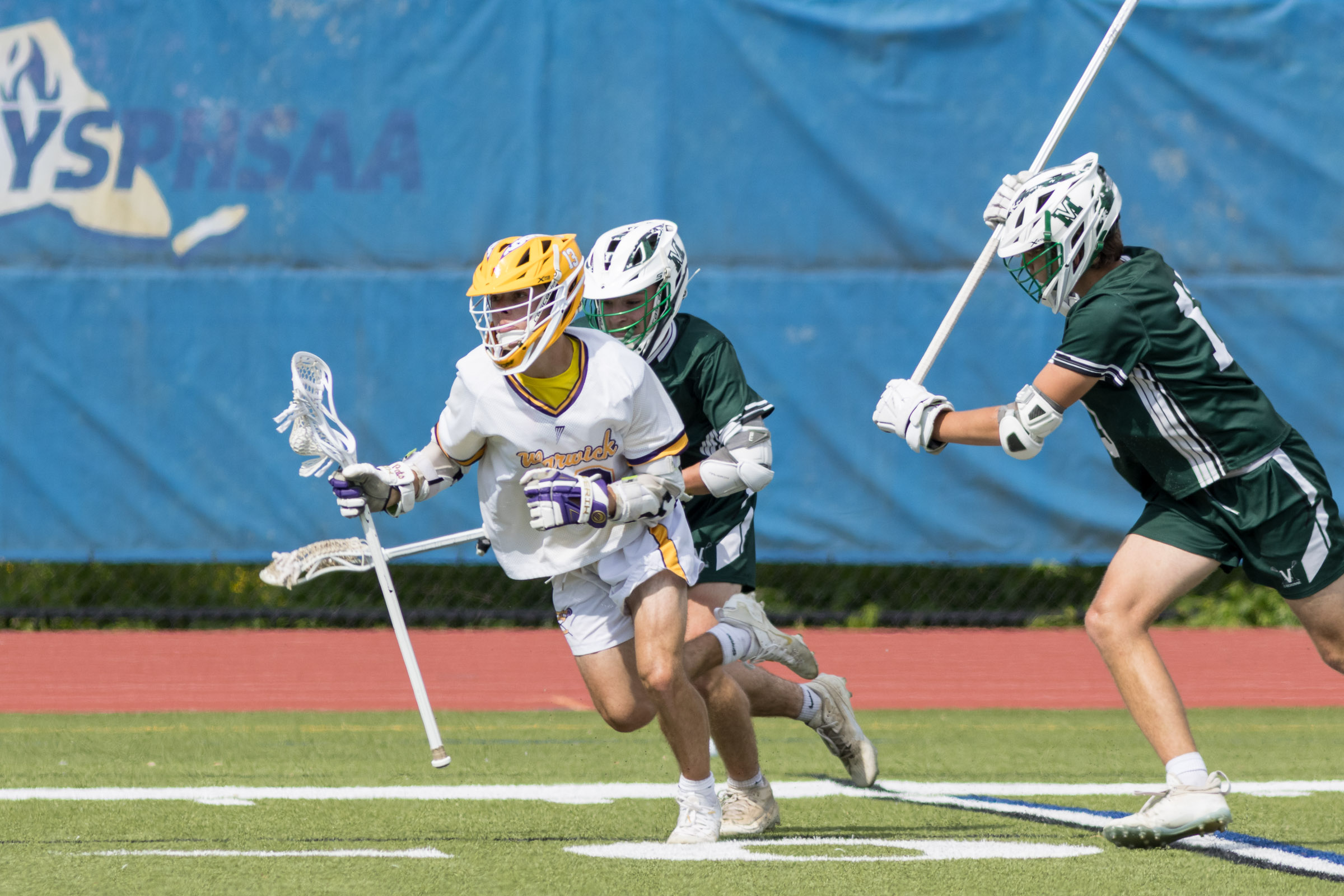 A Warwick Valley varsity boys lacrosse player carries the ball past two Minisink Valley players during the Section 9 Class B championship game.