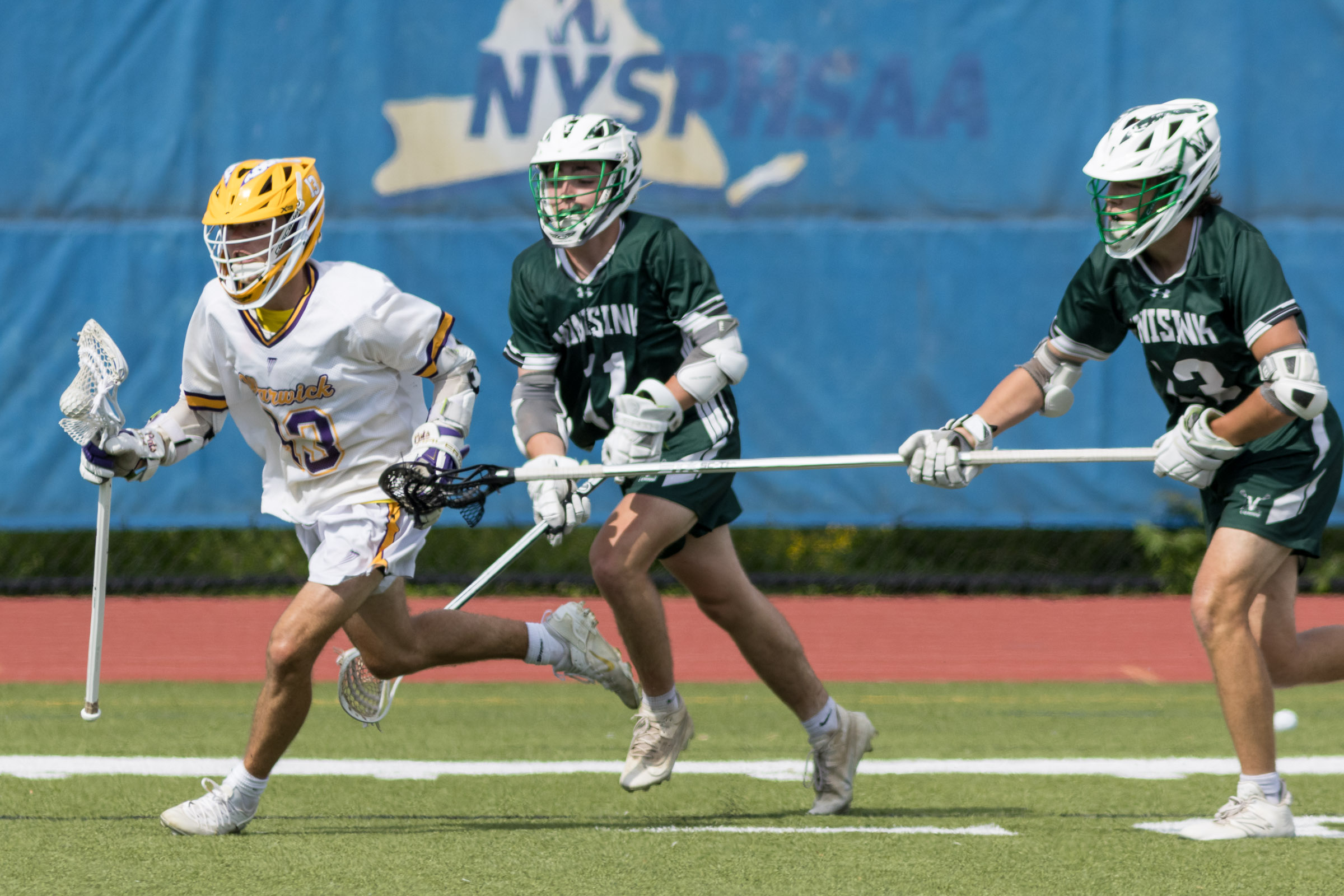 A Warwick Valley varsity boys lacrosse player carries the ball past two Minisink Valley players during the Section 9 Class B championship game.