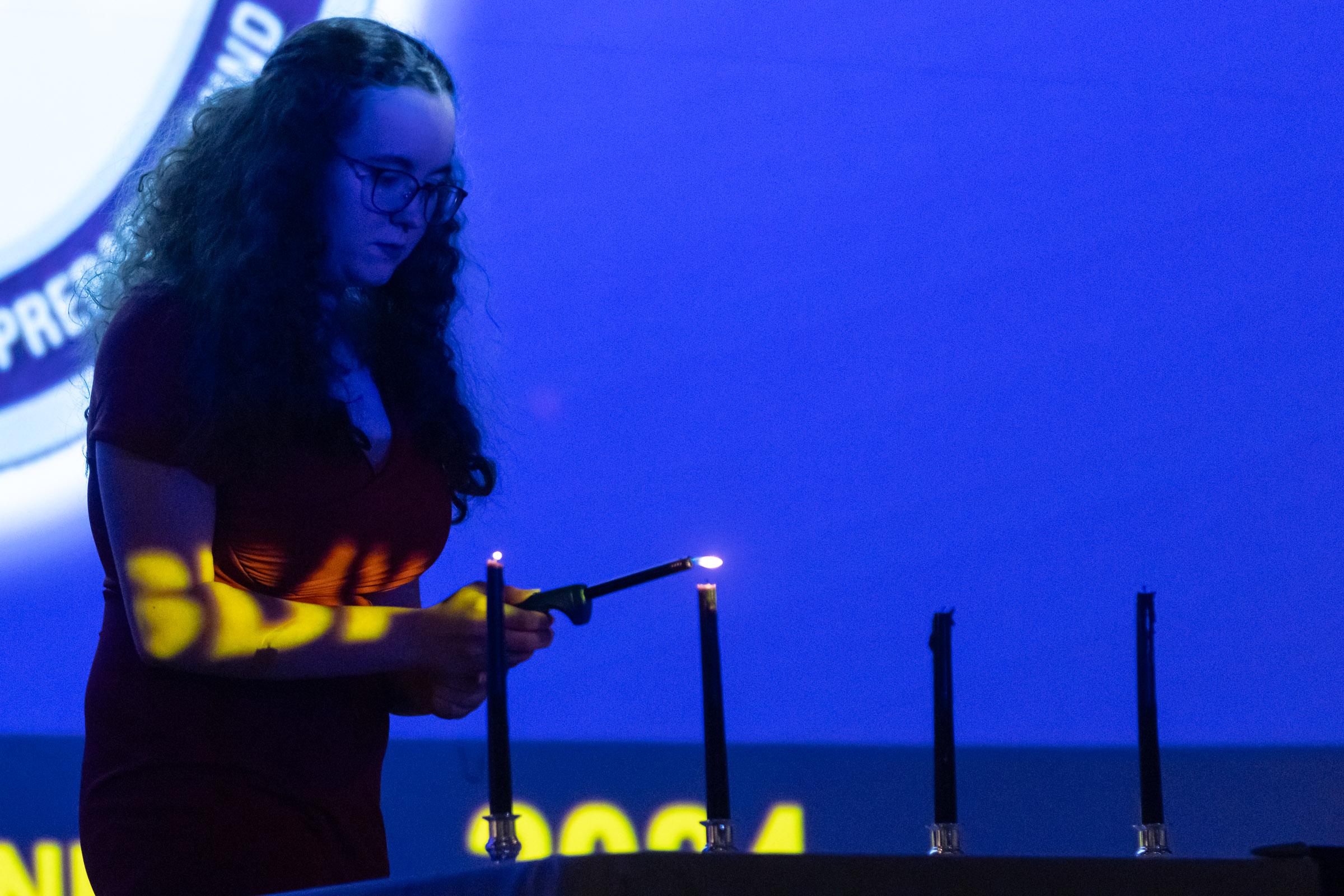 A student lights a candle during the Warwick Valley High School Career and Technical Education Recognition Ceremony and Honor Society Induction