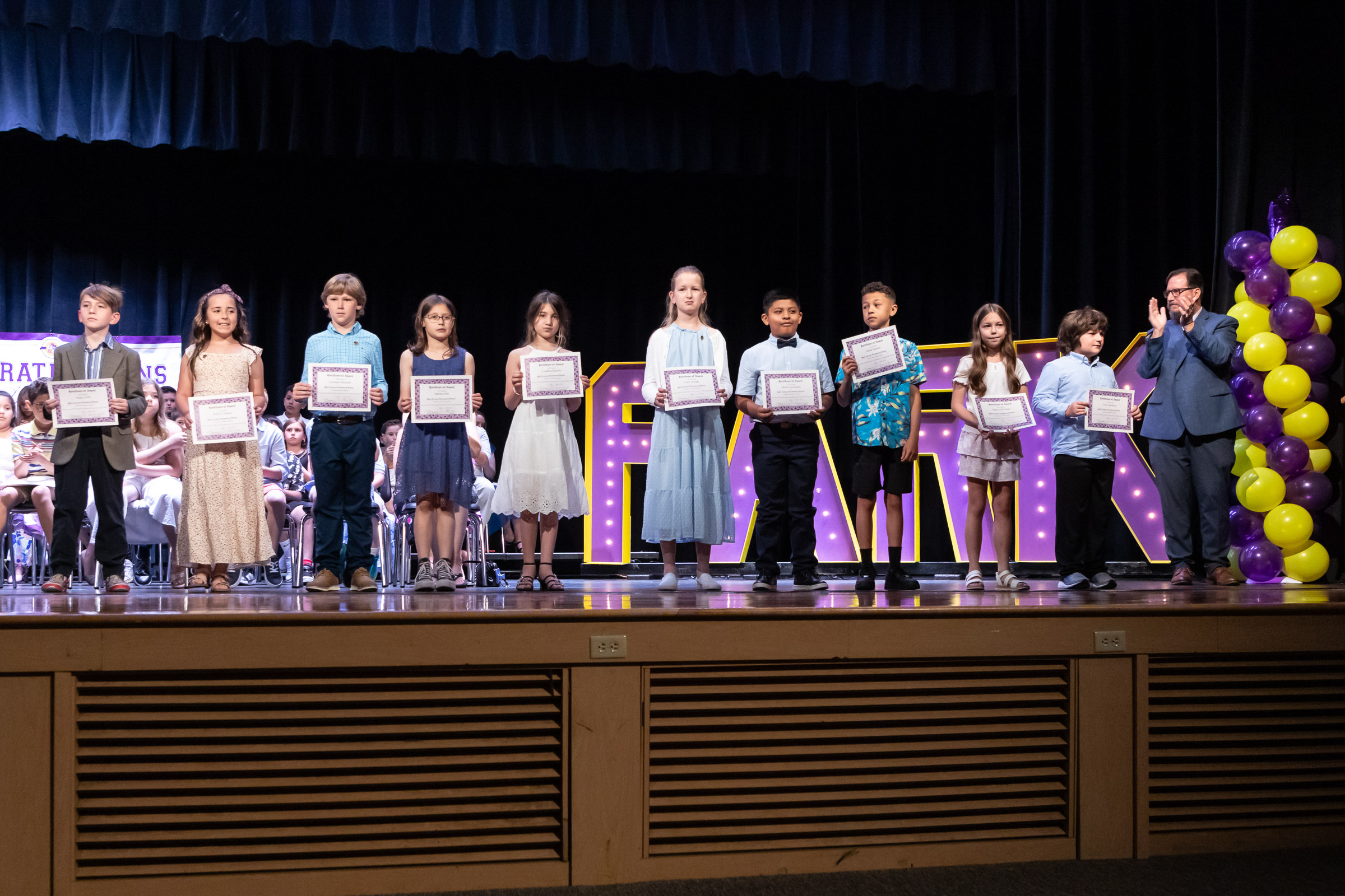 Students stand with their awards on stage during the Park Avenue Elementary School Fourth Grade Moving Up Ceremony in the WVHS auditorium