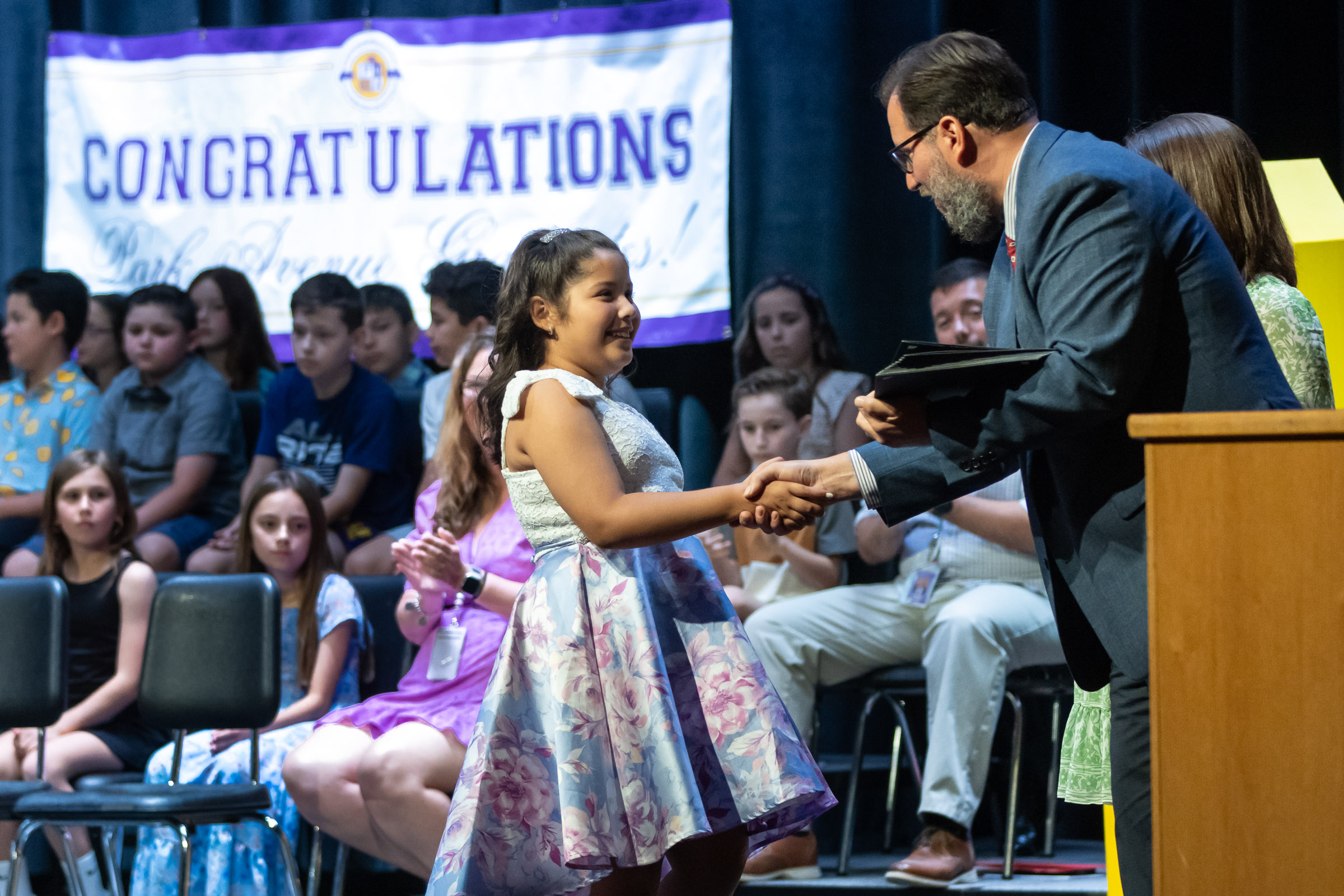 A students shakes hands with principal William Biniaris on stage during the Park Avenue Elementary School Fourth Grade Moving Up Ceremony in the WVHS auditorium