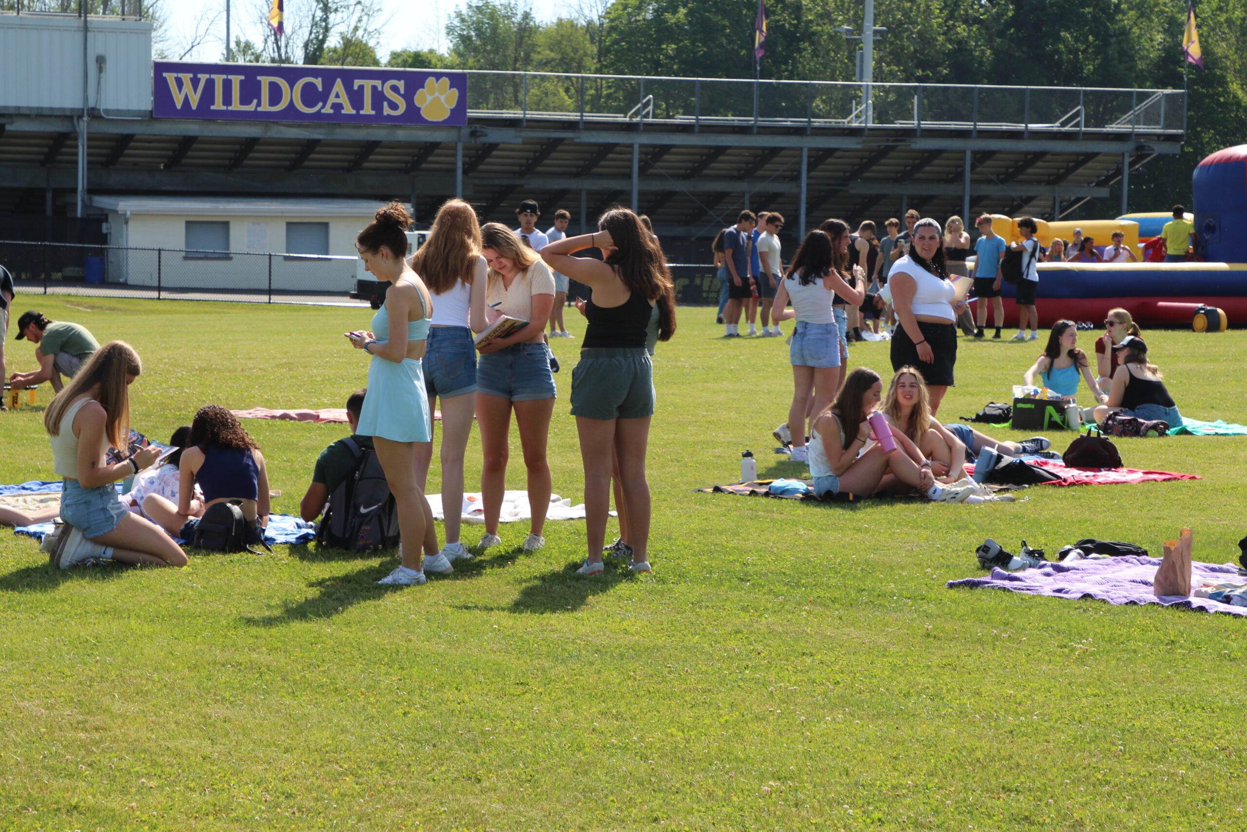 Warwick Valley High School seniors sign yearbooks and sit on blankets on the grass during their Senior Picnic