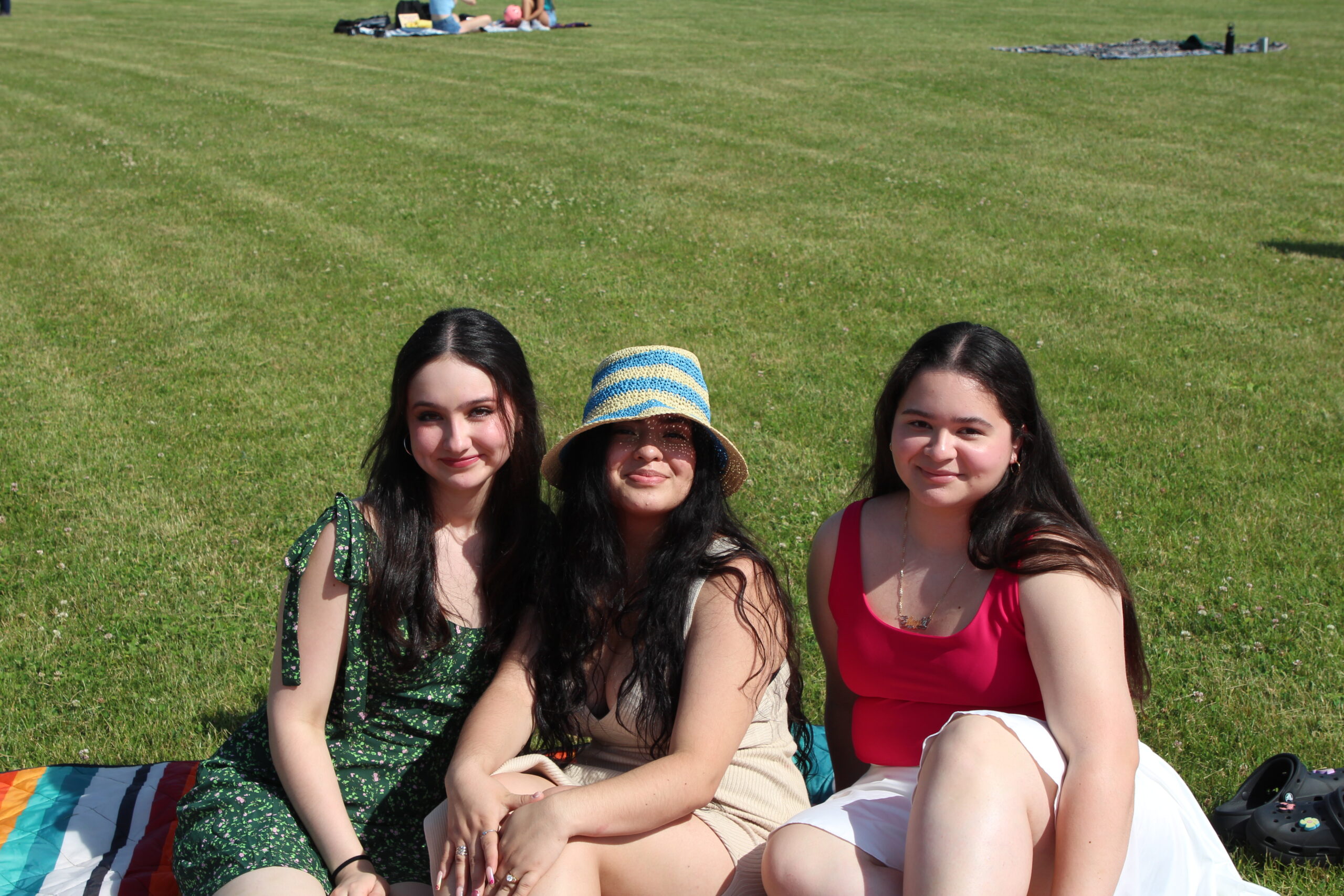 Warwick Valley High School seniors sit on blankets on the grass and smile during their Senior Picnic