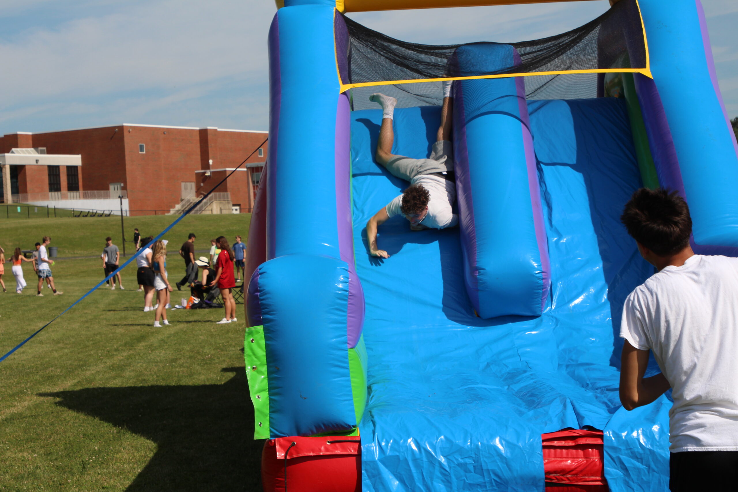 A Warwick Valley High School senior slides down a bouncy house during the Senior Picnic