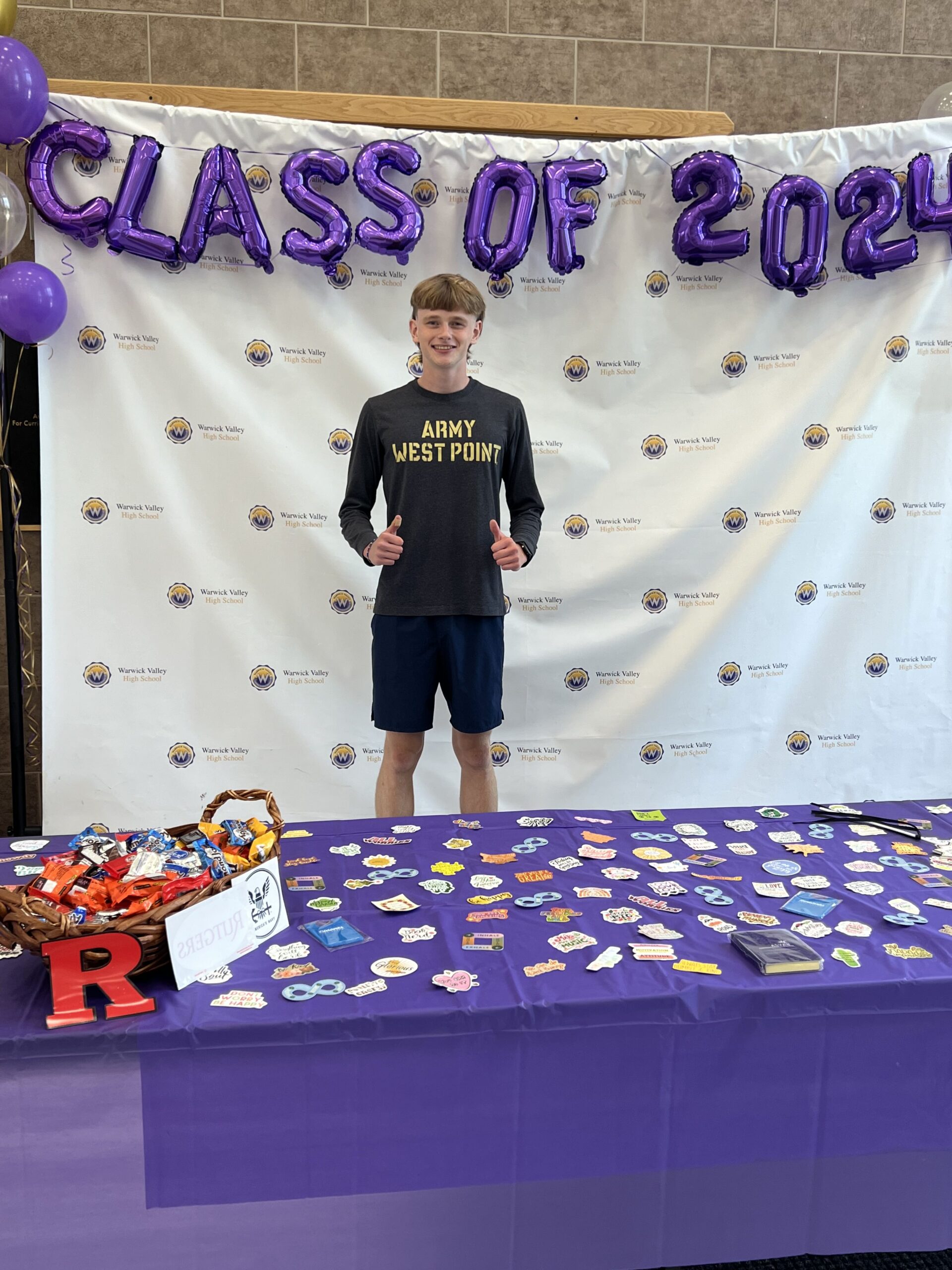 A WVHS senior stands under balloons reading "Class of 2024" on Decision Day, celebrating the Class of 2024 and the choices they’ve made about their post high school lives.