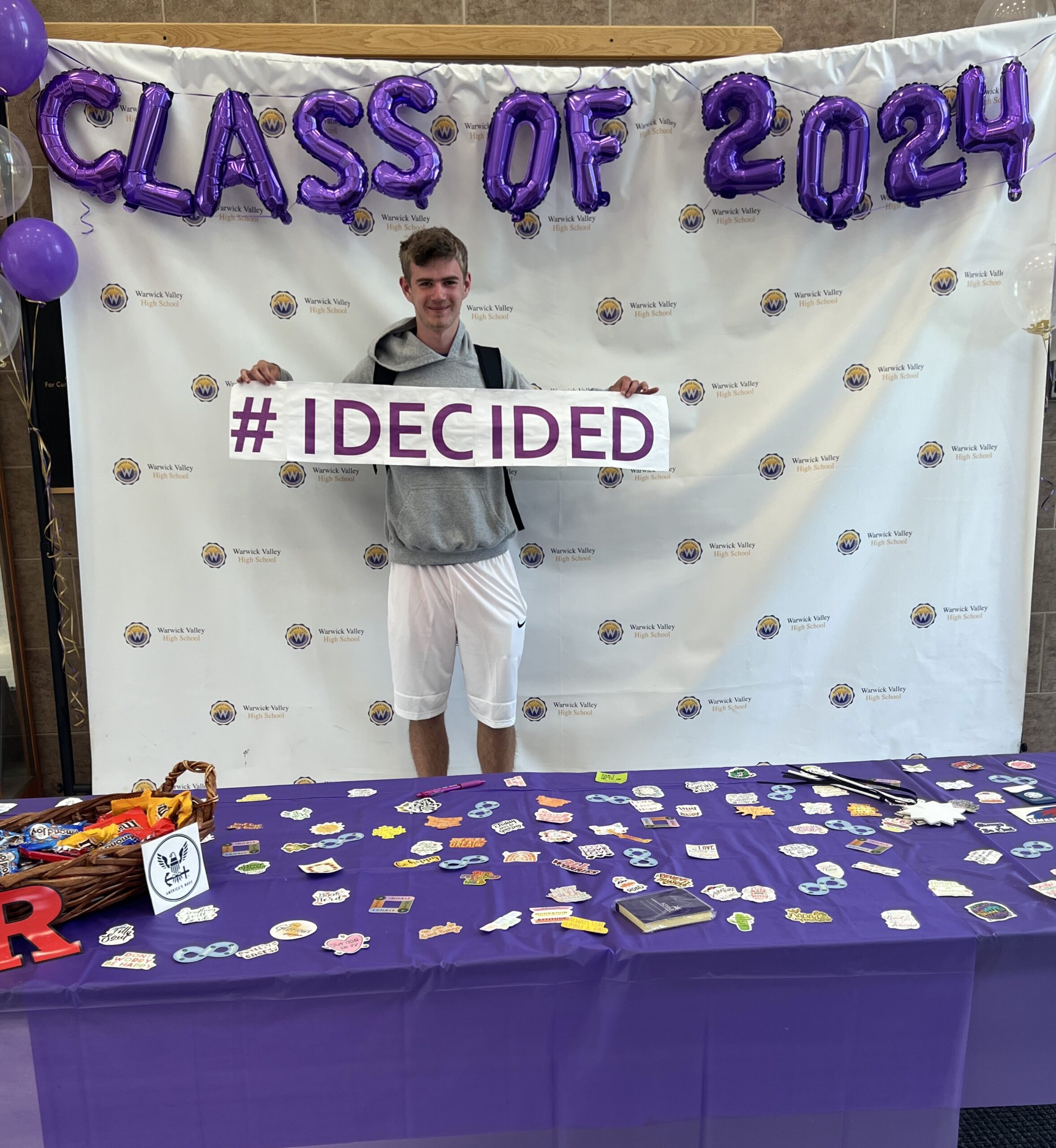 A WVHS senior holds an "I DECIDED" banner on Decision Day, celebrating the Class of 2024 and the choices they’ve made about their post high school lives.