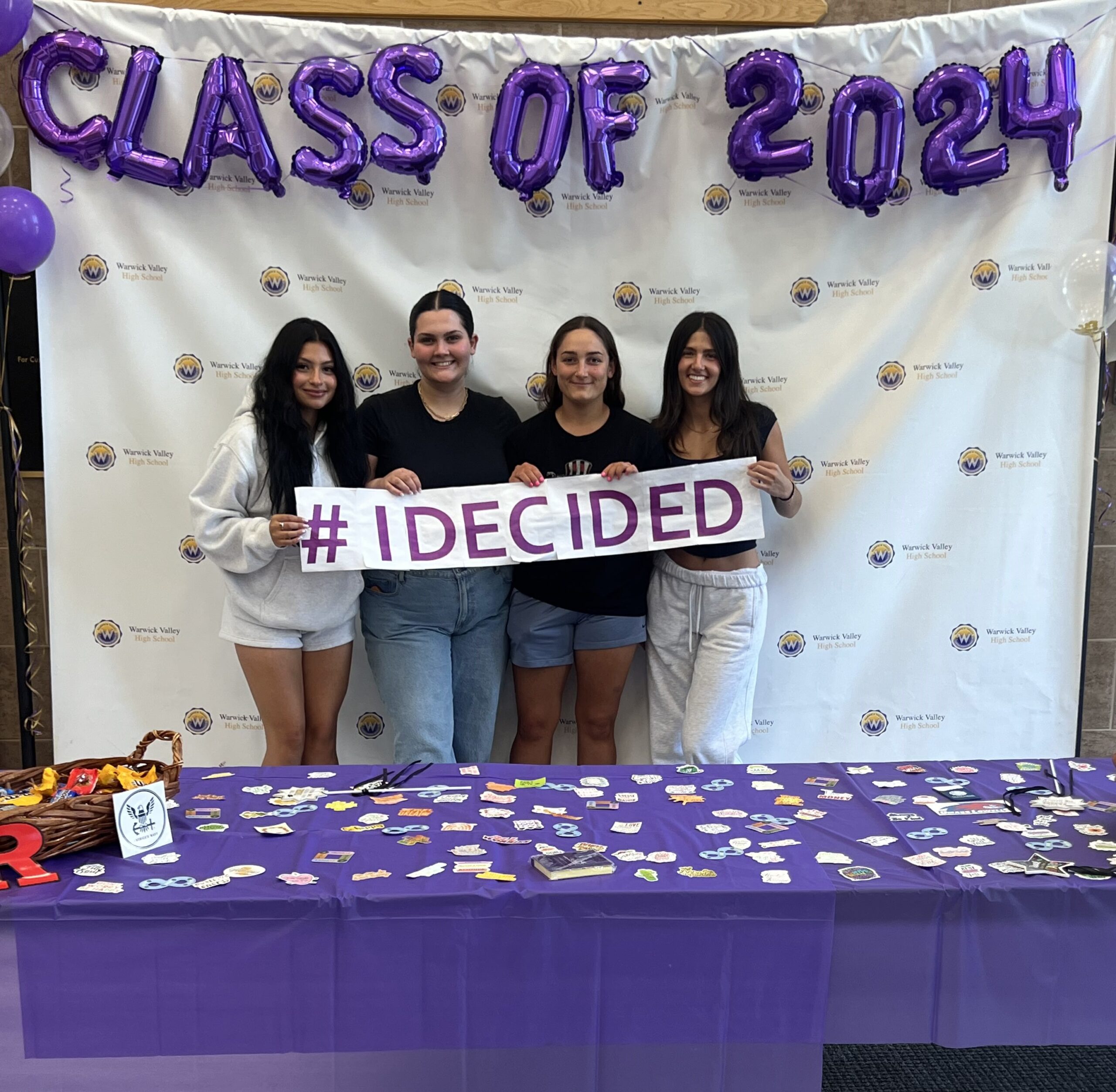 Four WVHS seniors hold an "I DECIDED" banner on Decision Day, celebrating the Class of 2024 and the choices they’ve made about their post high school lives.