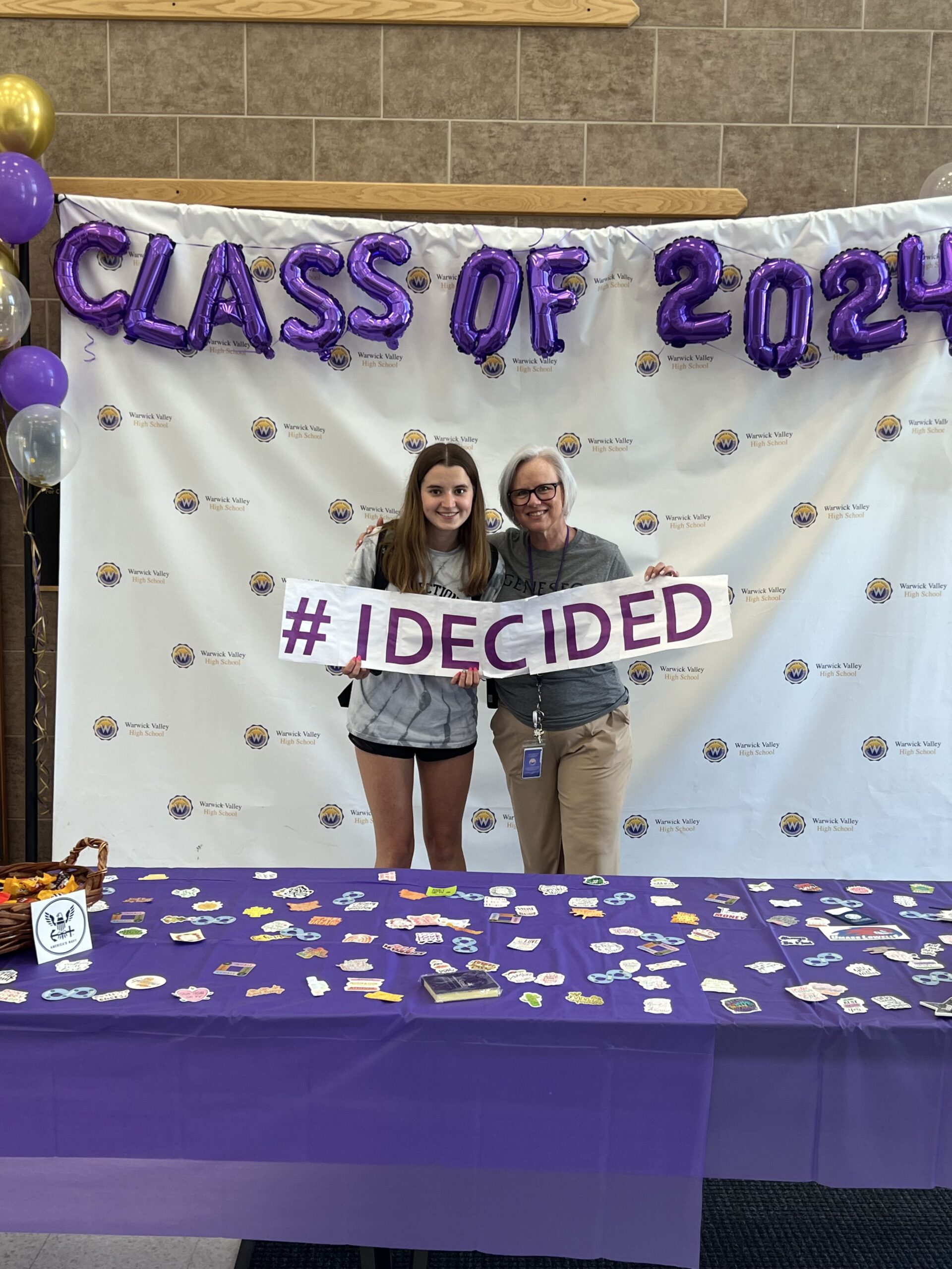 A WVHS senior and guidance counselor hold an "I DECIDED" banner on Decision Day, celebrating the Class of 2024 and the choices they’ve made about their post high school lives.