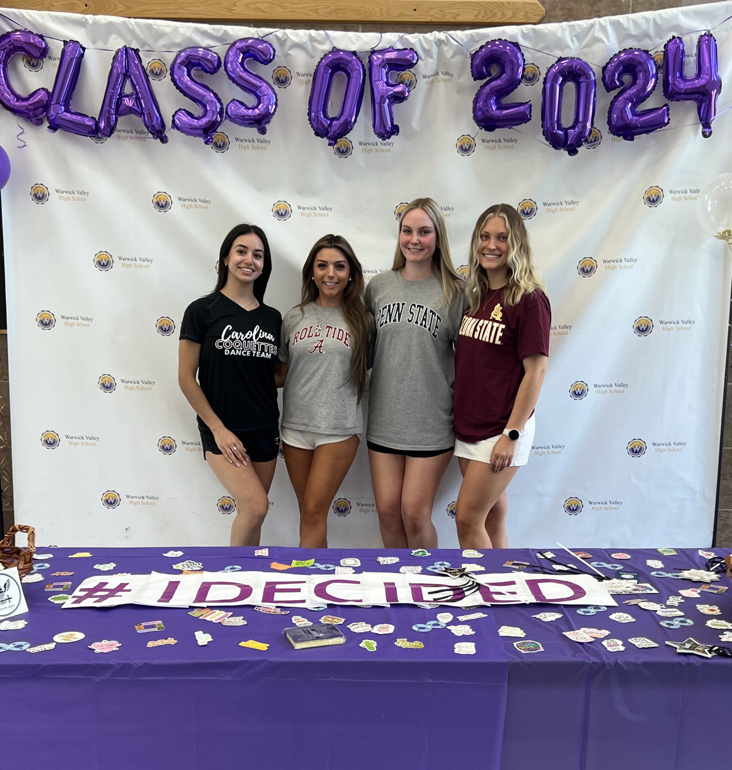 Four WVHS seniors stand under balloons reading "Class of 2024" and holds a sign reading "I'm Ready to Get to Work On Day One" on Decision Day, celebrating the Class of 2024 and the choices they’ve made about their post high school lives.