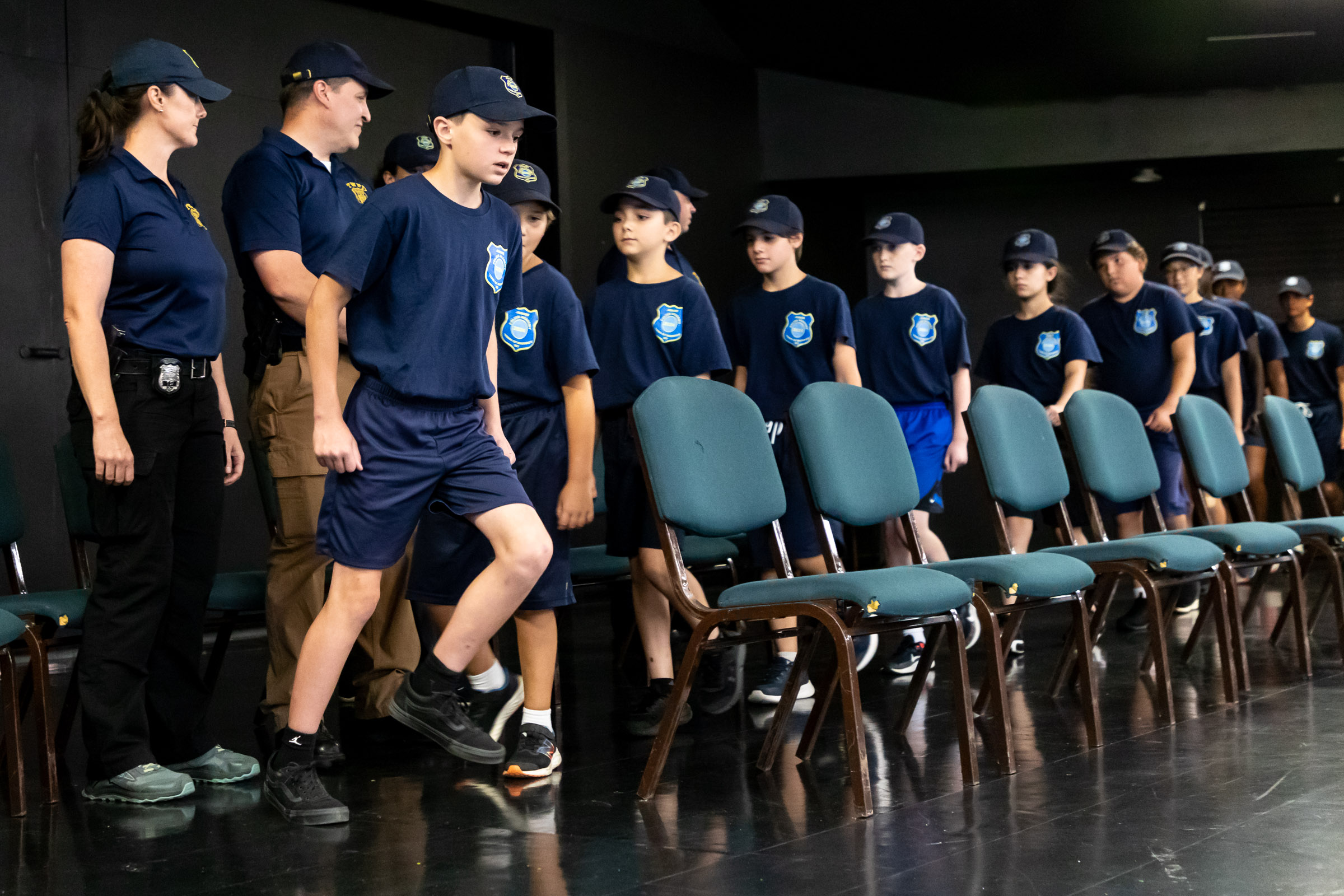 Cadets march onto the stage during the Warwick Police Department Junior Police Academy graduation in the theater at Mountain Lakes Park.