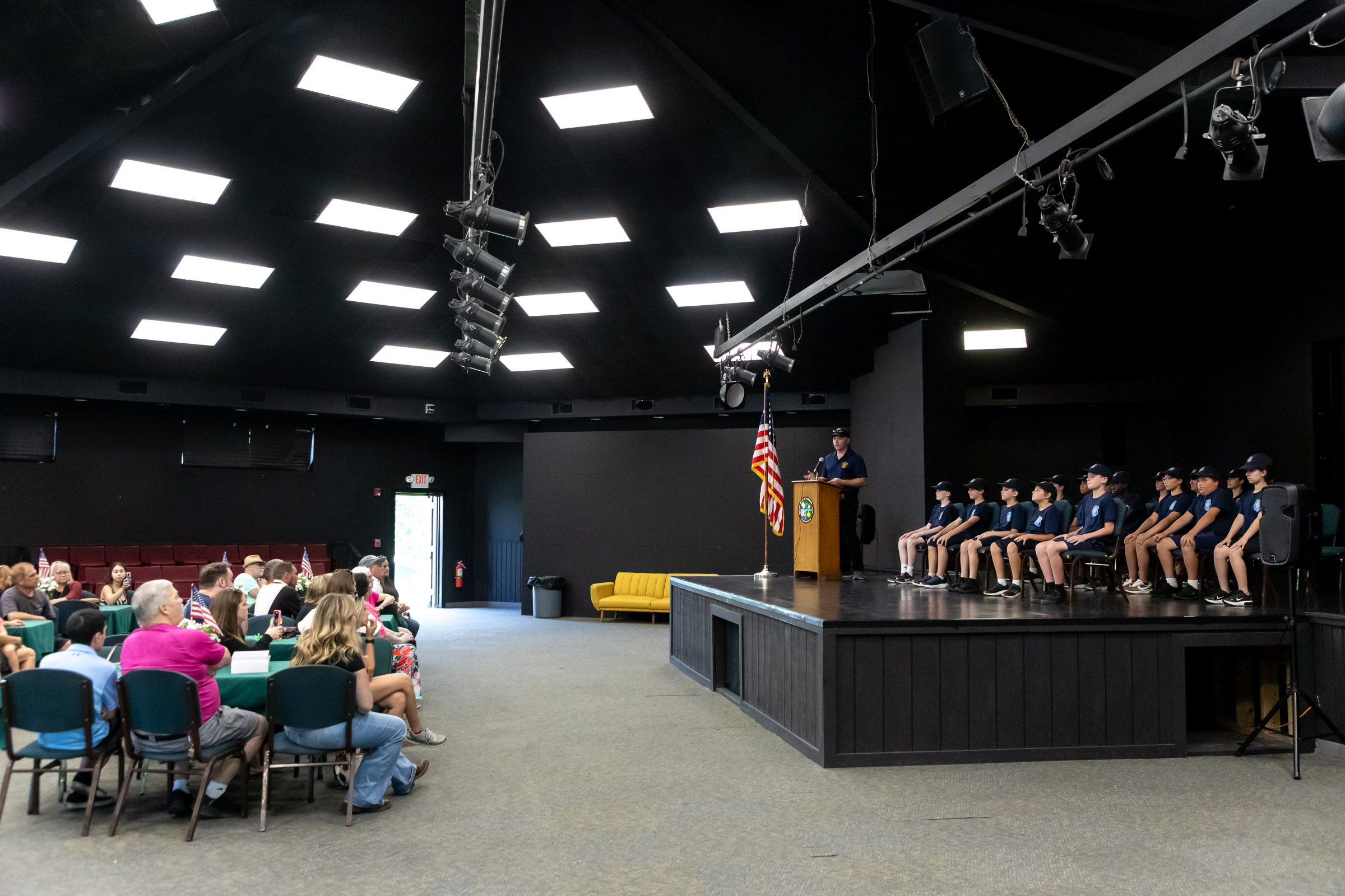 Eleven cadets sit on the stage as their families sit in the audience during Warwick Police Department Junior Police Academy graduation in the theater at Mountain Lakes Park.