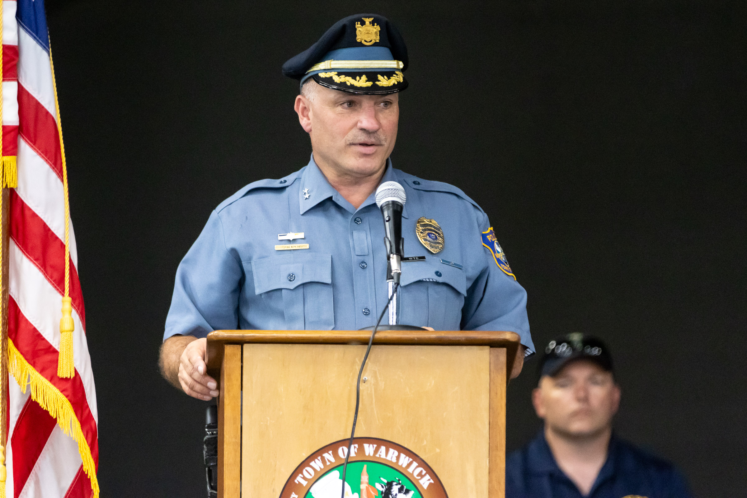 Police Chief John Rader speaks at the podium during the Town of Warwick Police Department Junior Police Academy graduation ceremony.