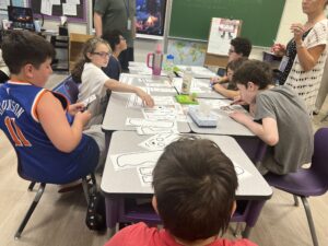 An extended school year program photo of students making binoculars