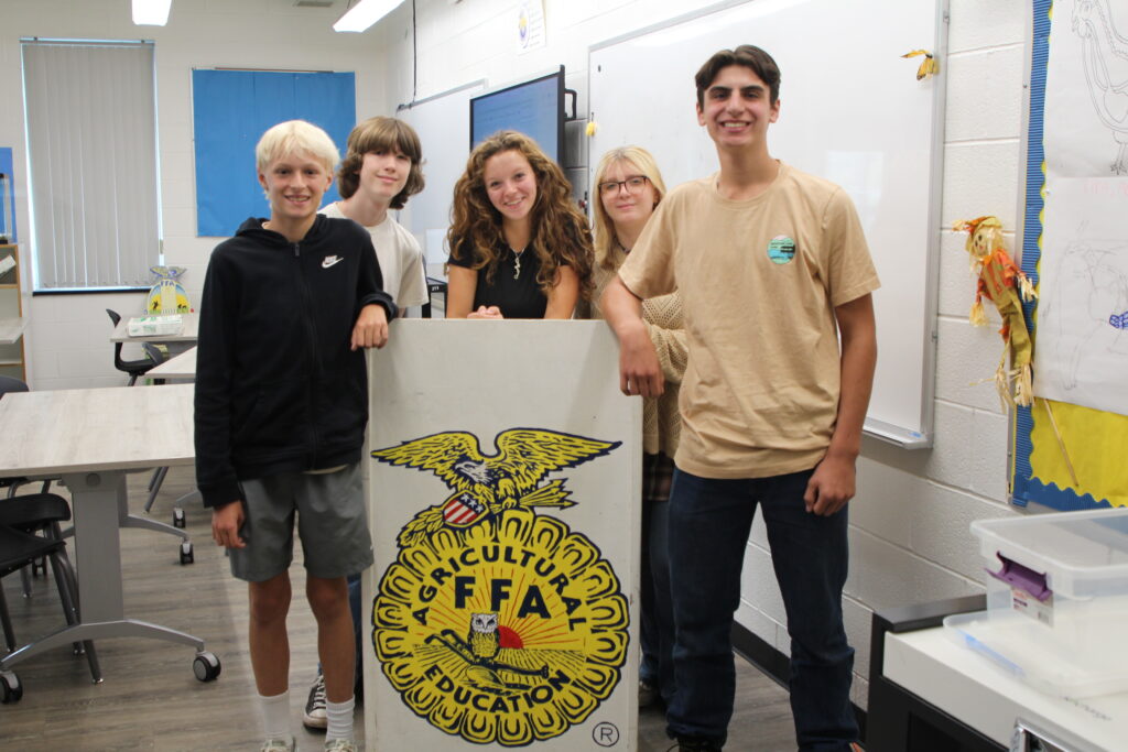 Five WVHS agriculture students at a podium with an FFA emblem