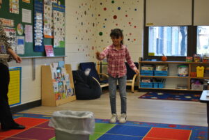 student participating in basketball activity in class